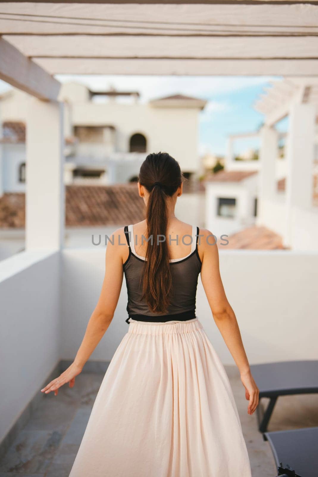 A graceful and elegant woman wearing a flowing skirt is enjoying the beautiful outdoors in a serene setting