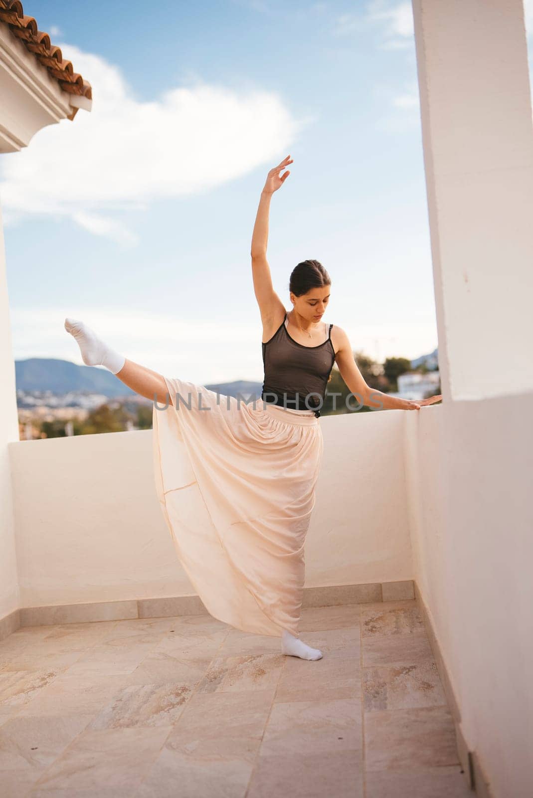 A skilled dancer strikes an elegant pose on a charming balcony, showcasing a beautiful dance in nature