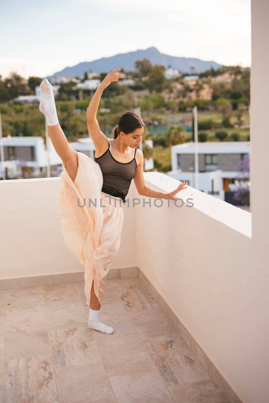 An elegant dancer strikes a beautifully poised ballet pose against a breathtakingly stunning backdrop scenery