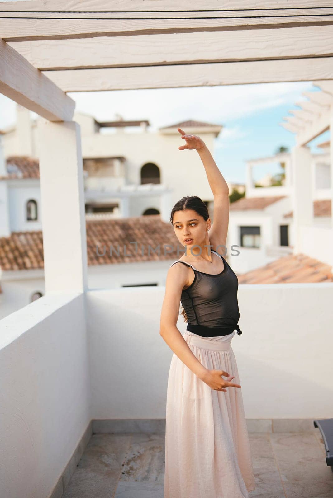 A talented dancer beautifully showcases her grace and skill in a picturesque outdoor setting with a stunning backdrop