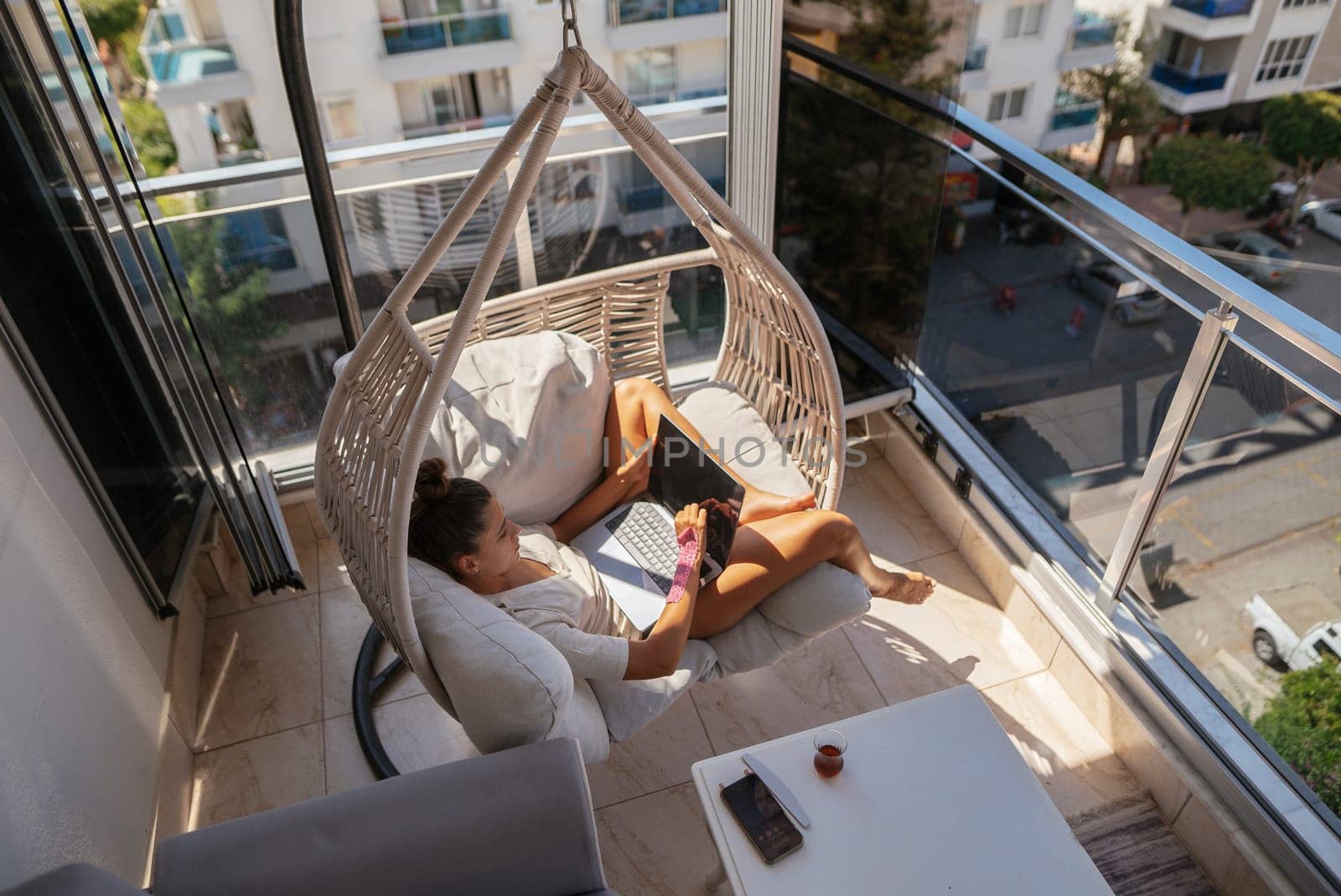 Enjoying a peaceful moment in a stylish hammock on the balcony with a good book and a refreshing drink