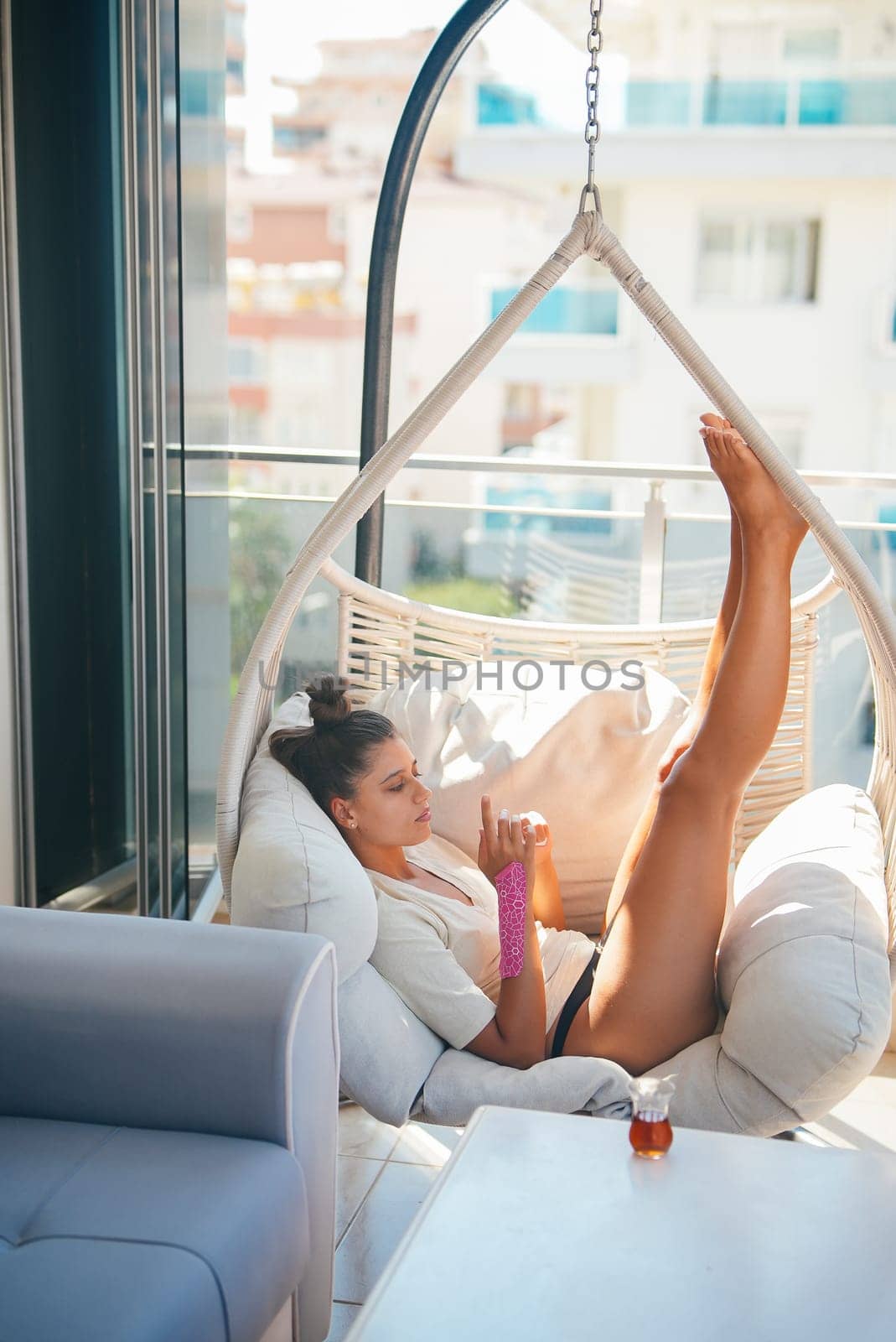 A woman is enjoying her leisure time as she relaxes in a cozy hammock, radiating calmness and tranquility