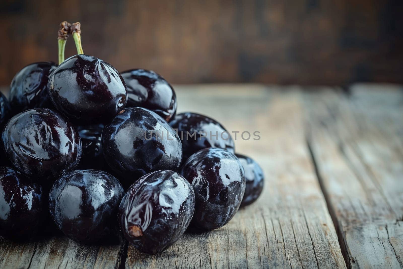 A stunning display of rich, shiny black prunes stacked neatly, showcasing their luscious texture against a beautifully aged wooden surface that adds warmth.