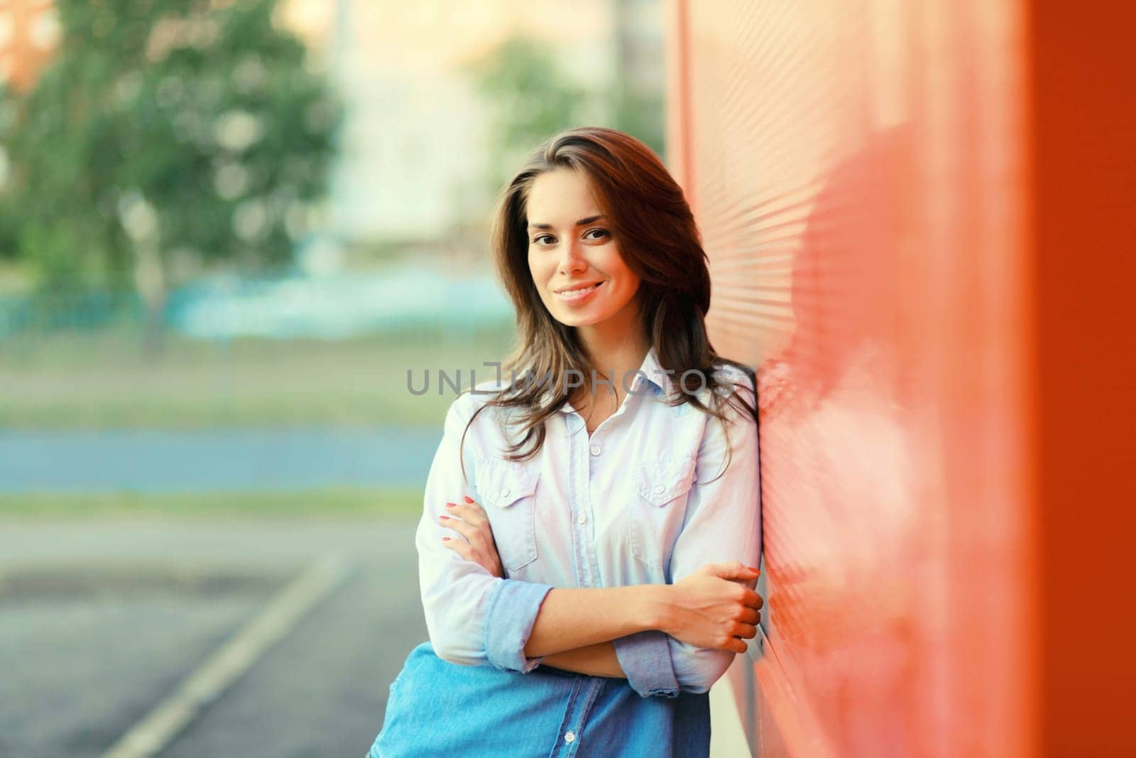 Portrait of beautiful happy smiling brunette young woman posing in the city