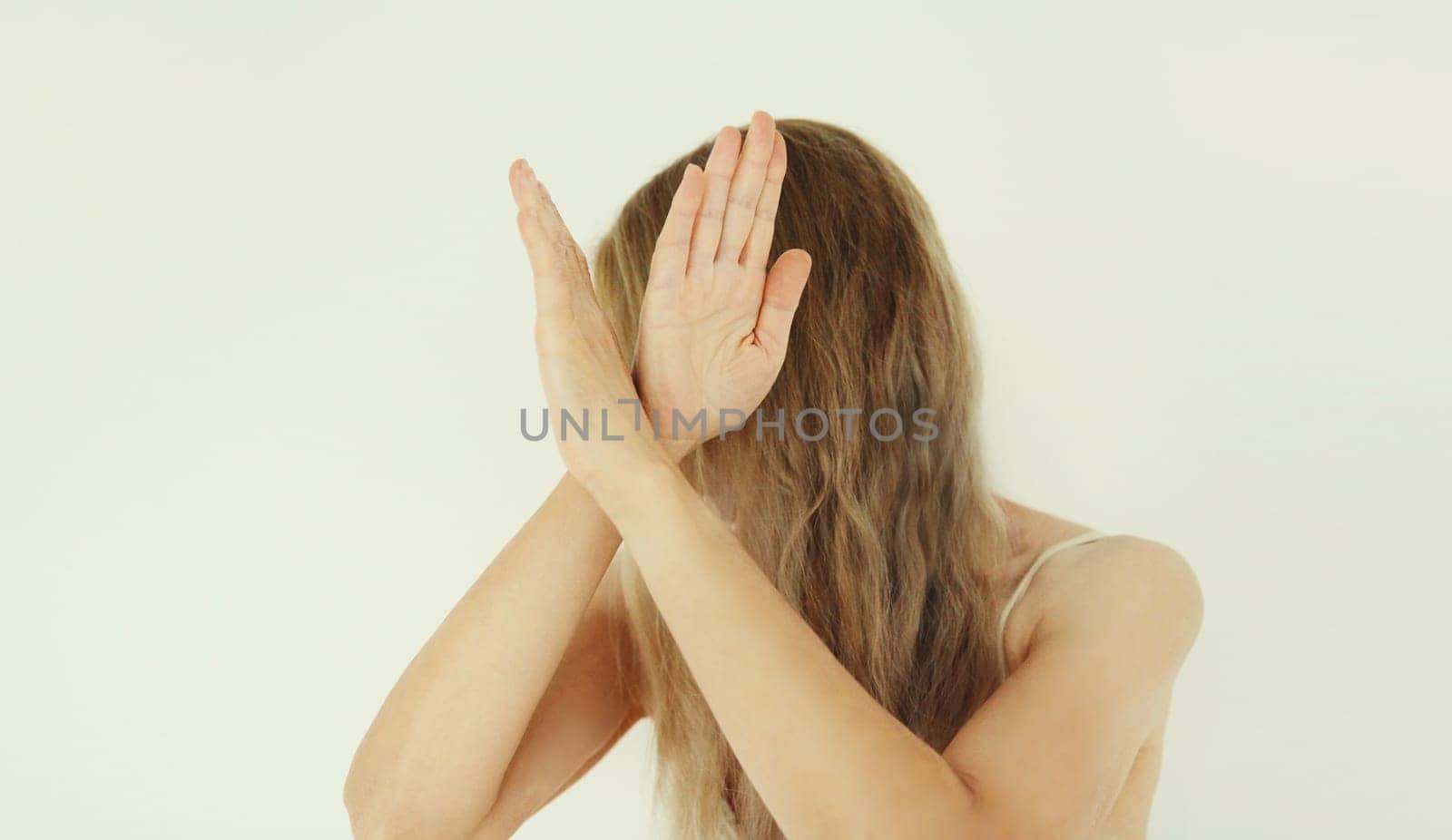 Upset woman shows stop, no or enough sign with palm of hand, refusal gesture, domestic violence.