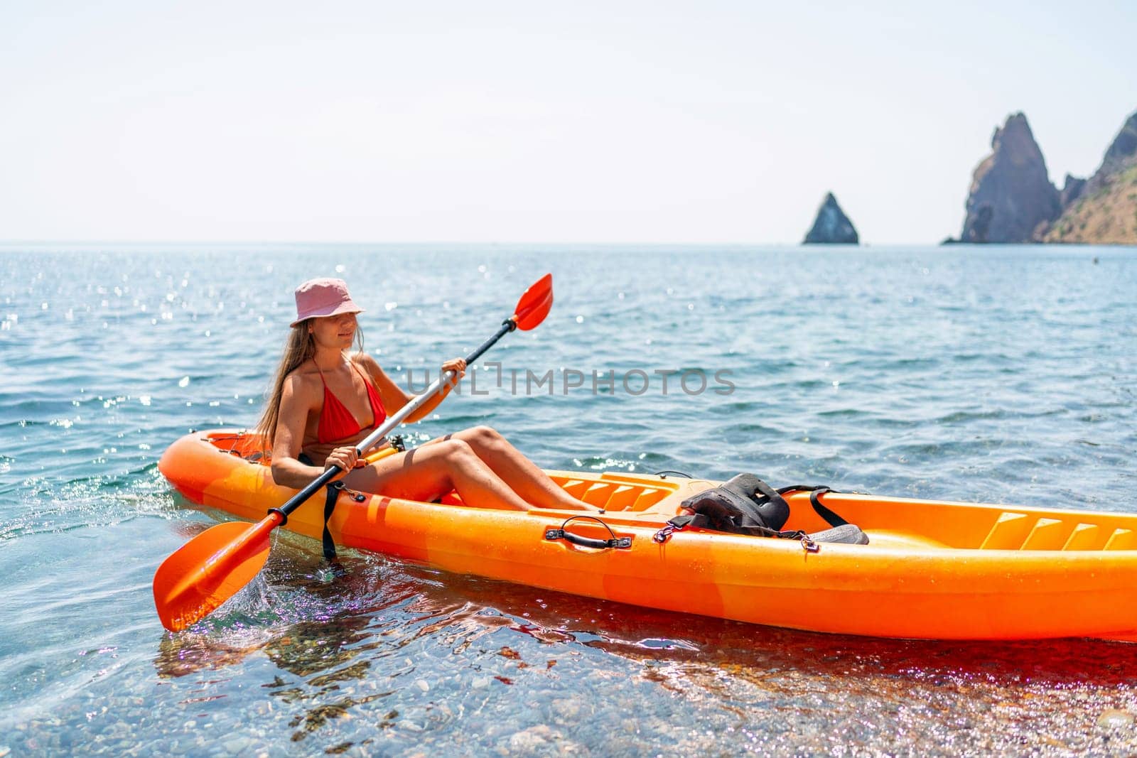 Kayak sea woman. Happy attractive woman with long hair in red swimsuit, swimming on kayak. Summer holiday vacation and travel concept