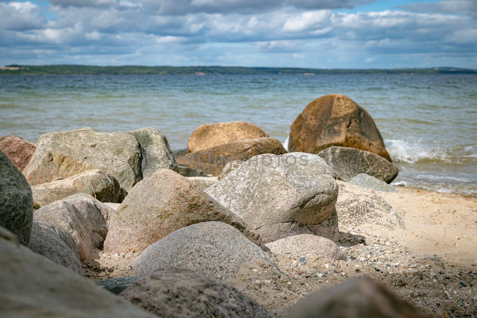 beach with rochs in denmark trelde naes at the kattegat water