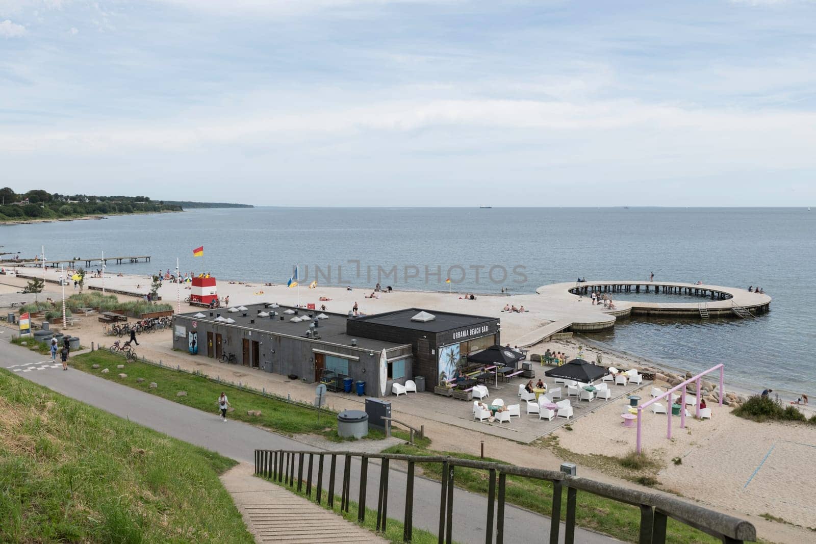 Fredericia, Jutland, Denmark, July 25, 2024 - Sandy beach at the city coastline with people enjoy the summer and sun