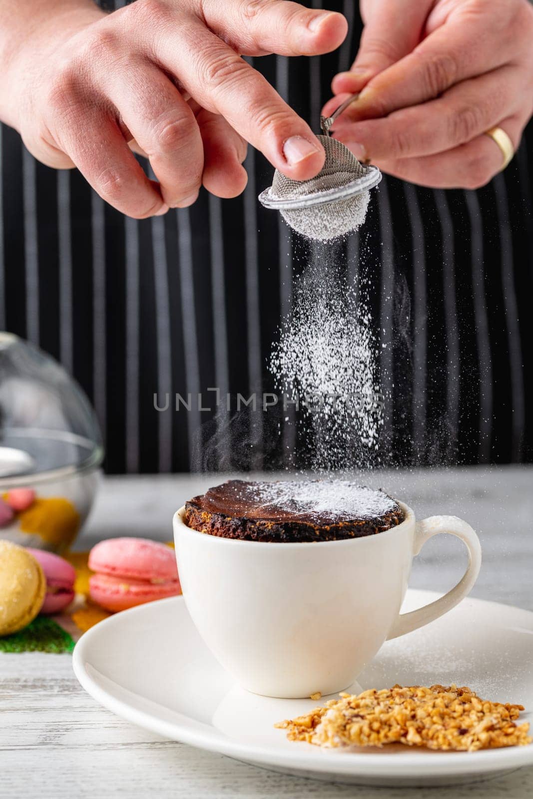 Chocolate soufflé in white porcelain cup on wooden table by Sonat