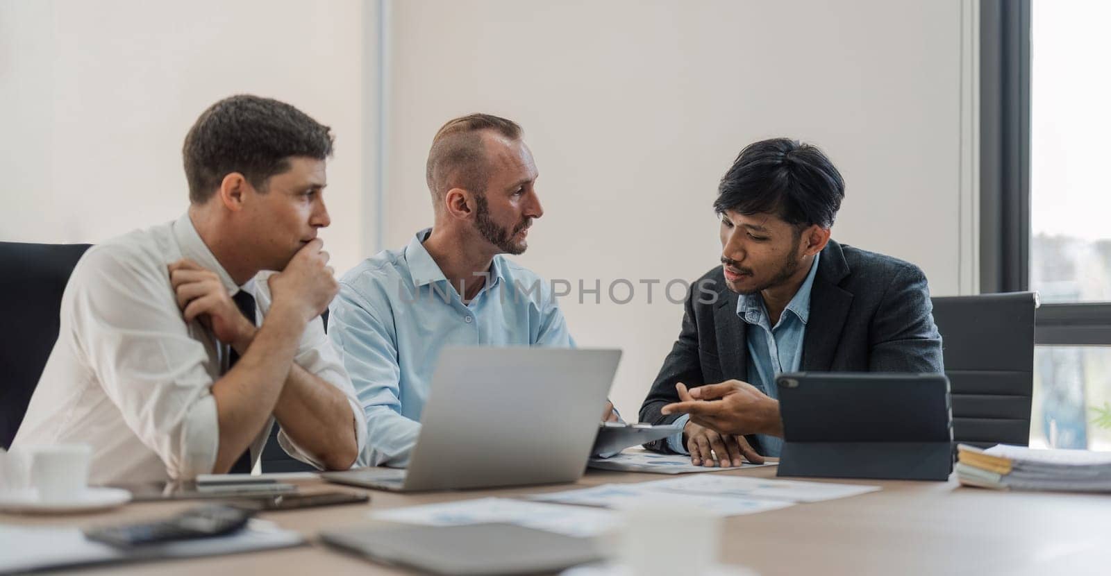 Business People Meeting using laptop computer,calculator,notebook,stock market chart paper for analysis Plans to improve quality next month. Conference Discussion Corporate Concept by wichayada