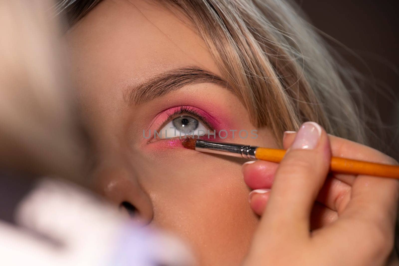 girl getting makeup, done pink eye shadow , close-up