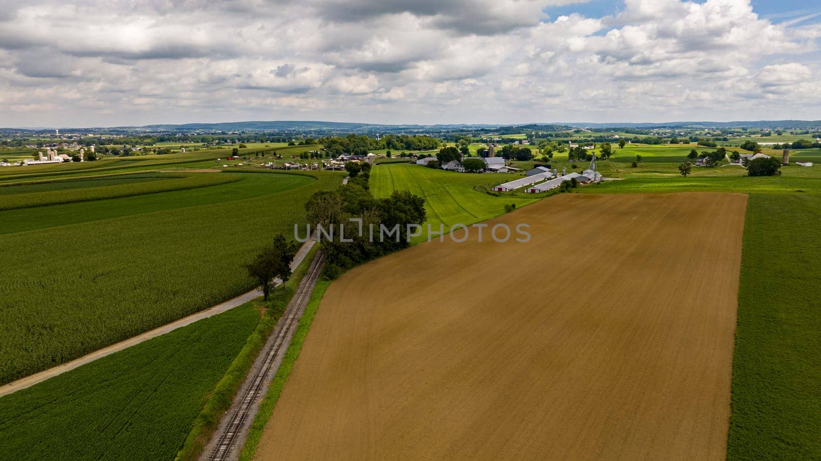 Aerial View of Rural America, with Farmlands and a Single Rail Road Track Going Thru it by actionphoto50