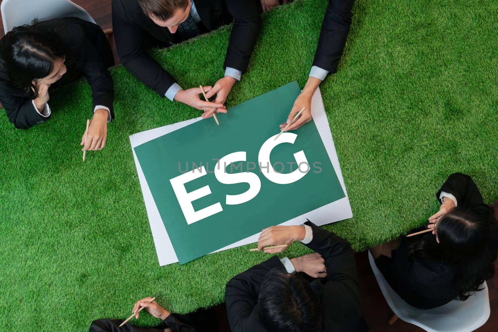 Top view panoramic banner ESG symbol on green grass meeting table with group of diverse business people planning marketing with eco-friendly awareness as environmental social governance concept.Quaint