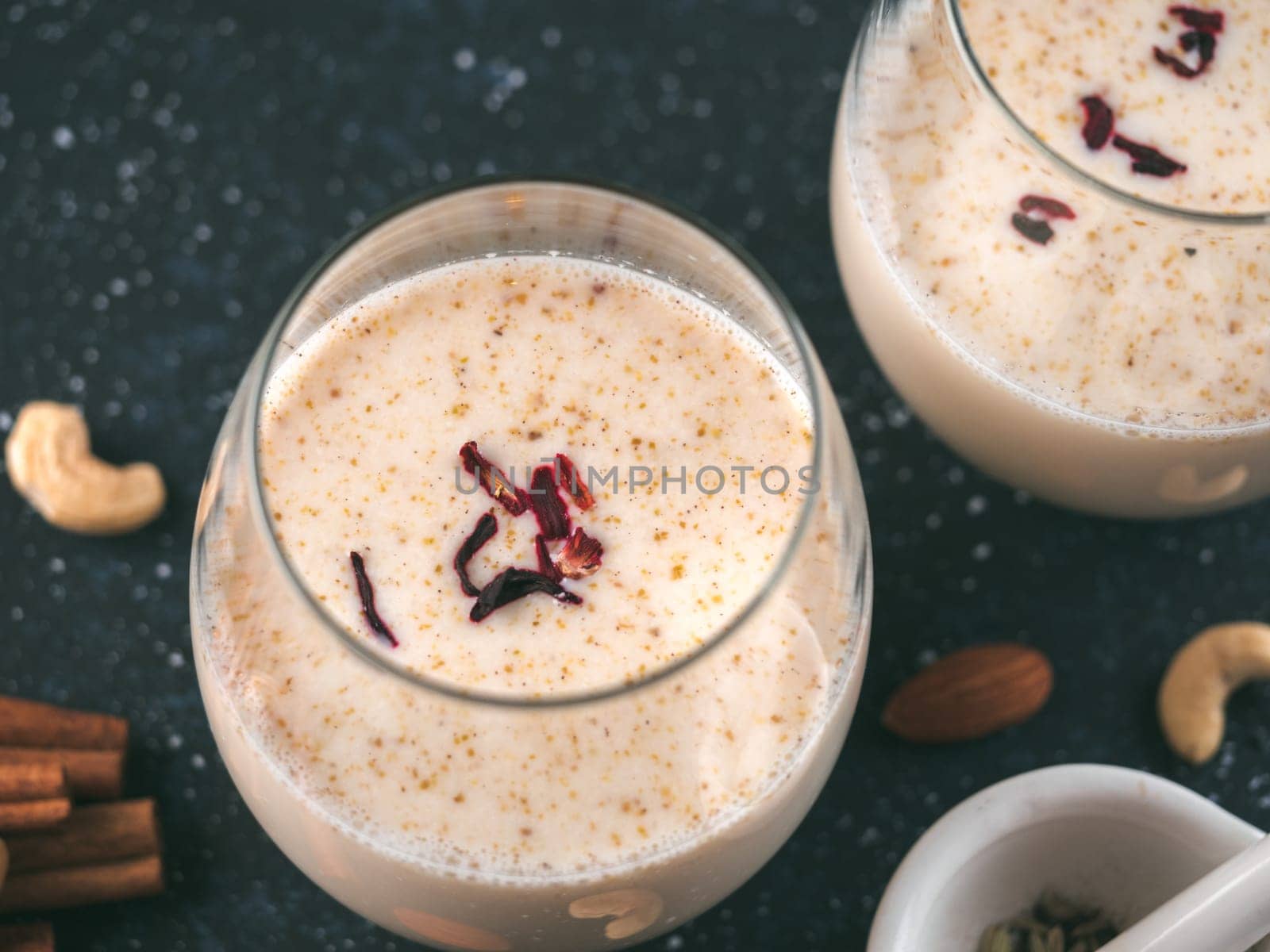 Thandai or Sardai cold drink made during Holi festival. Cold milk drink in glass, with ingredients - nuts and spices. Copy space