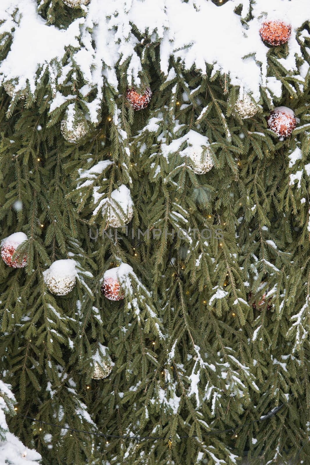 Christmas trees decorated with red balloons in front of the cafe entrance. Street New Year decorations.