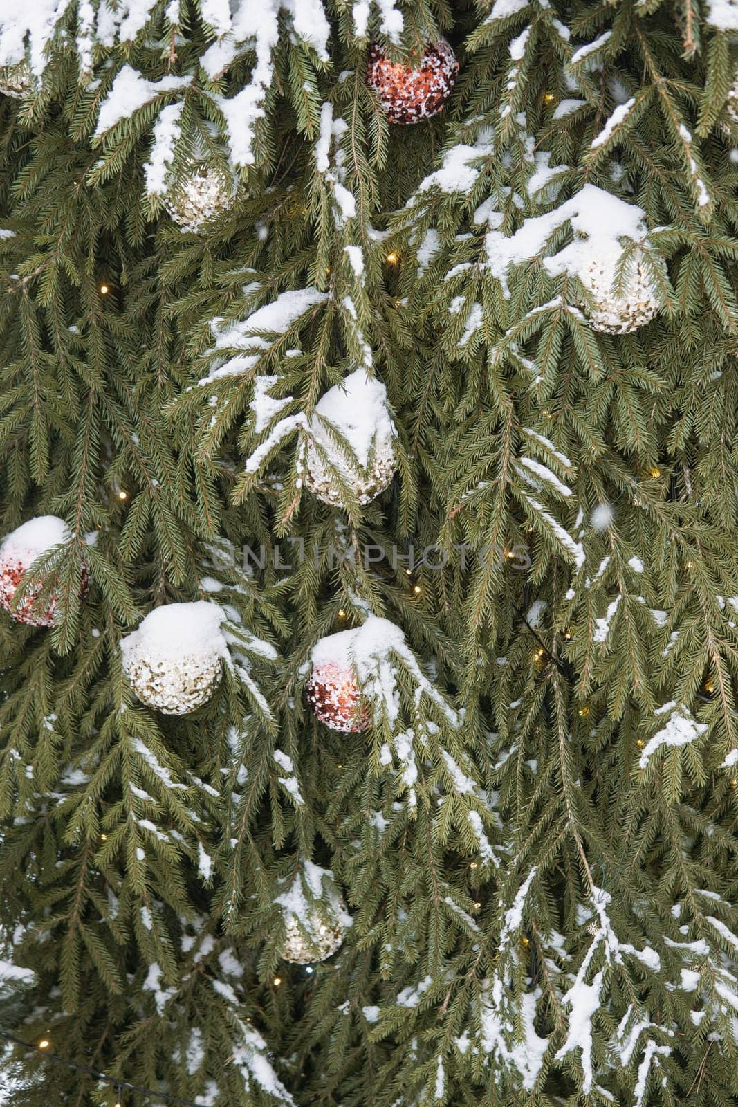 Christmas trees decorated with red balloons in front of the cafe entrance. Street New Year decorations.
