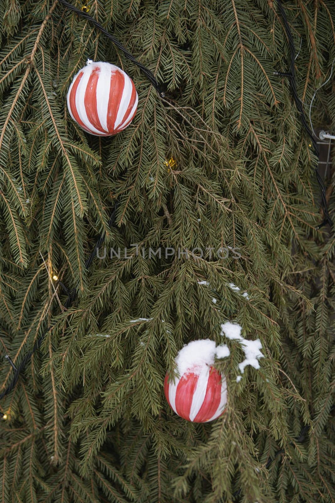 Christmas trees decorated with red balloons in front of the cafe entrance. Street New Year decorations.