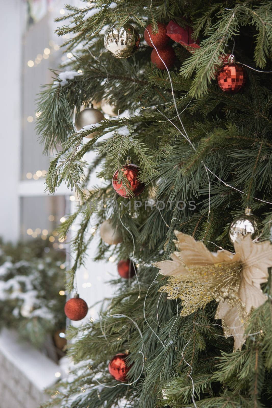 Christmas trees decorated with red balloons in front of the cafe entrance. Street New Year decorations.