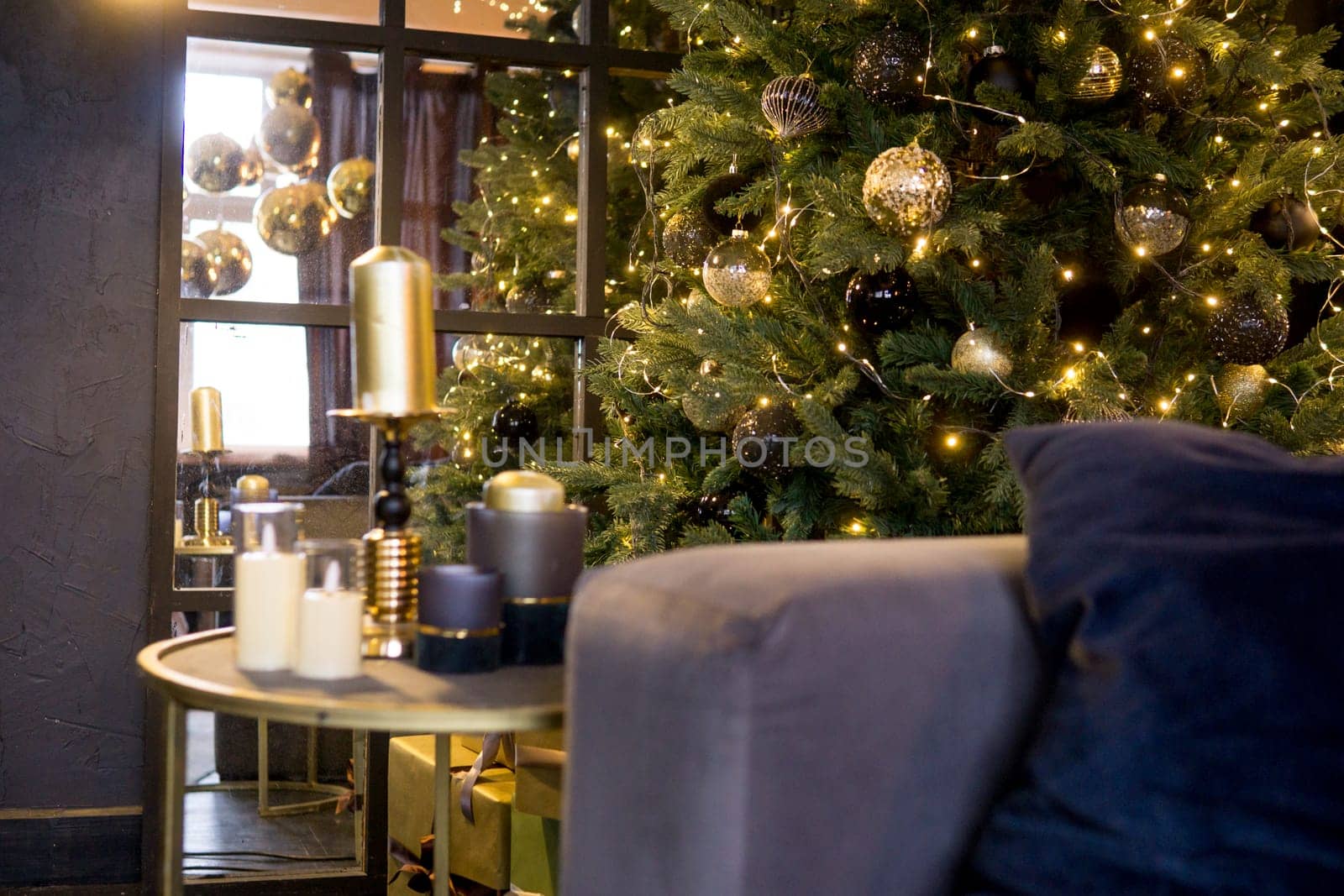 Christmas interior with a beautiful Christmas tree, sofa, light bulbs and dark background