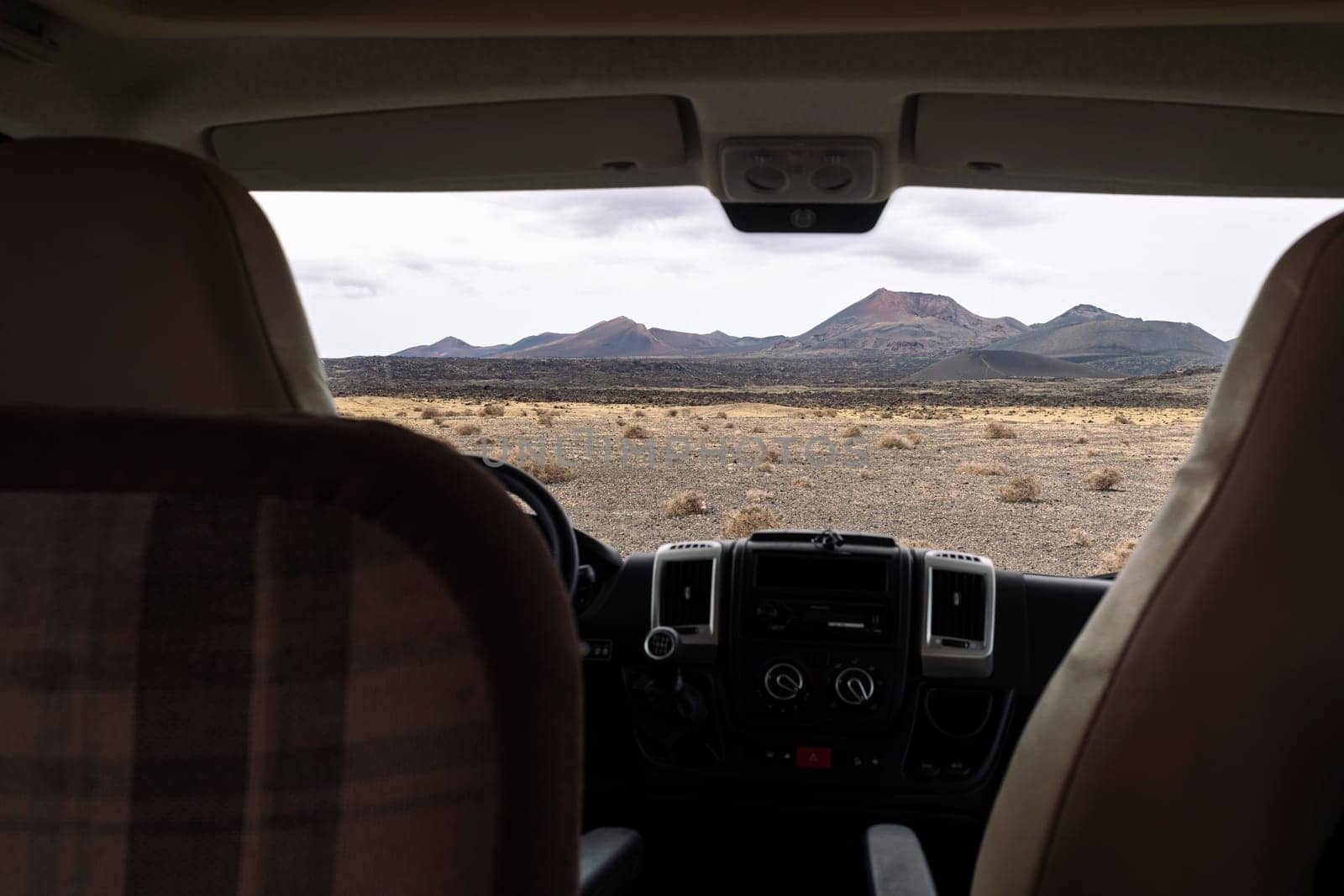 from inside vehicle view of volcano Cuervo and mount under cloudy sky in Tinajo, Lanzarote at Canary Islands Spain, concept of travel and adventure in nature