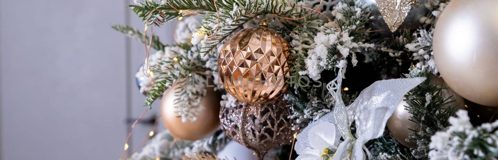 Golden textured ornament on the Christmas tree with bokeh lights background. Christmas and New Year concept