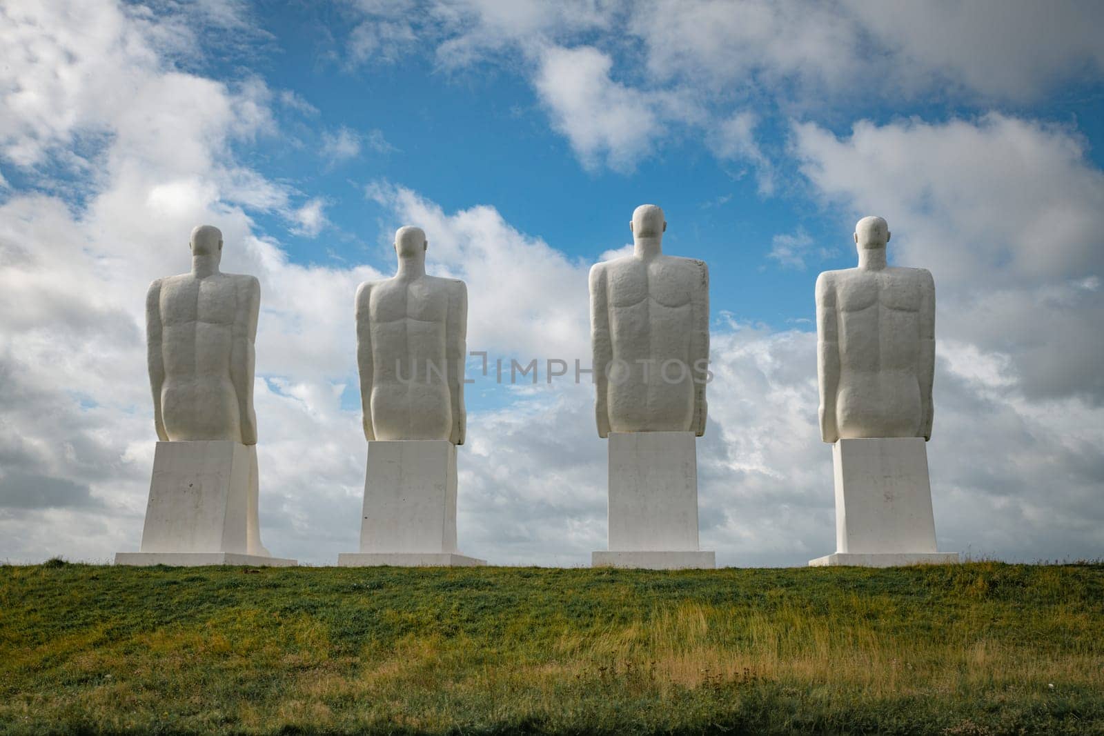 White Men statues, Esbjerg, Denmark. Four white men sitting looking at the sea near Esbjerg, Denmark. They are each 9 meters tall and made of white concrete.