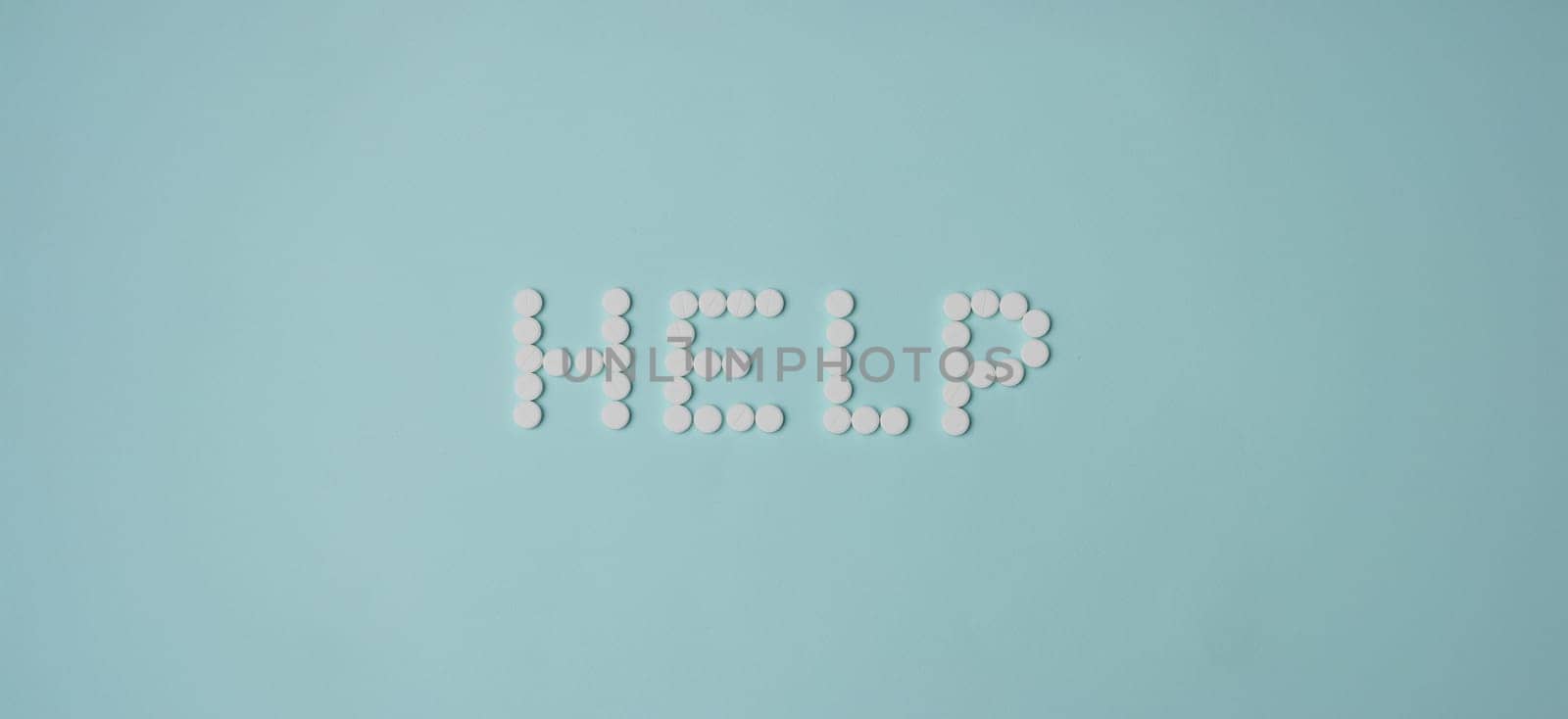 Top view of help lettering made with white round shaped pill, drug prescription for treatment. Pharmaceutical medicament, medicine, emergency, help concept