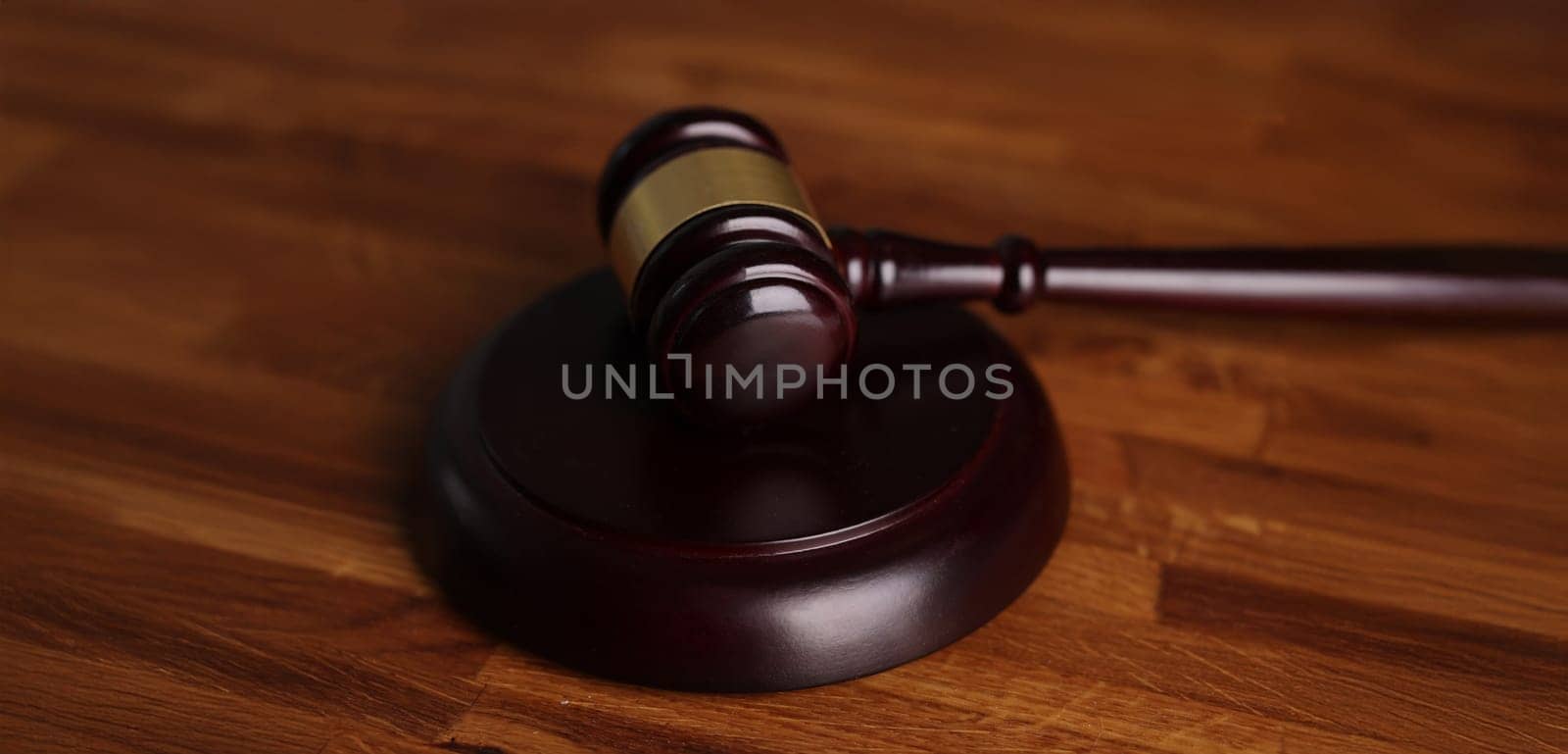 Close-up of judges wooden hammer on soundboard placed on wooden table. Attorney tool for legal service. Court, law, verdict, legality and justice concept