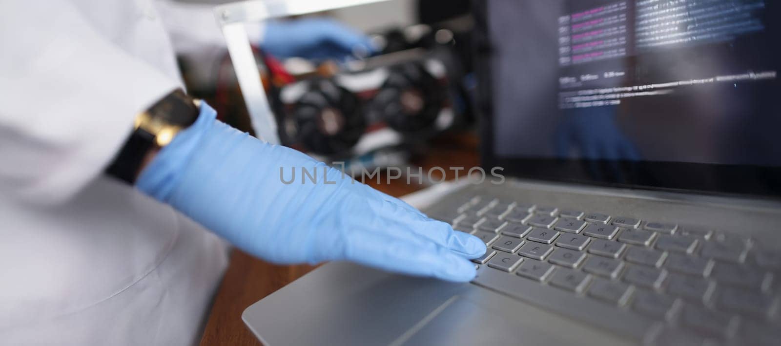 Close-up of professional technician man touching laptop keyboard wearing sterile gloves. Person check device on hidden failure. Tech maintenance concept