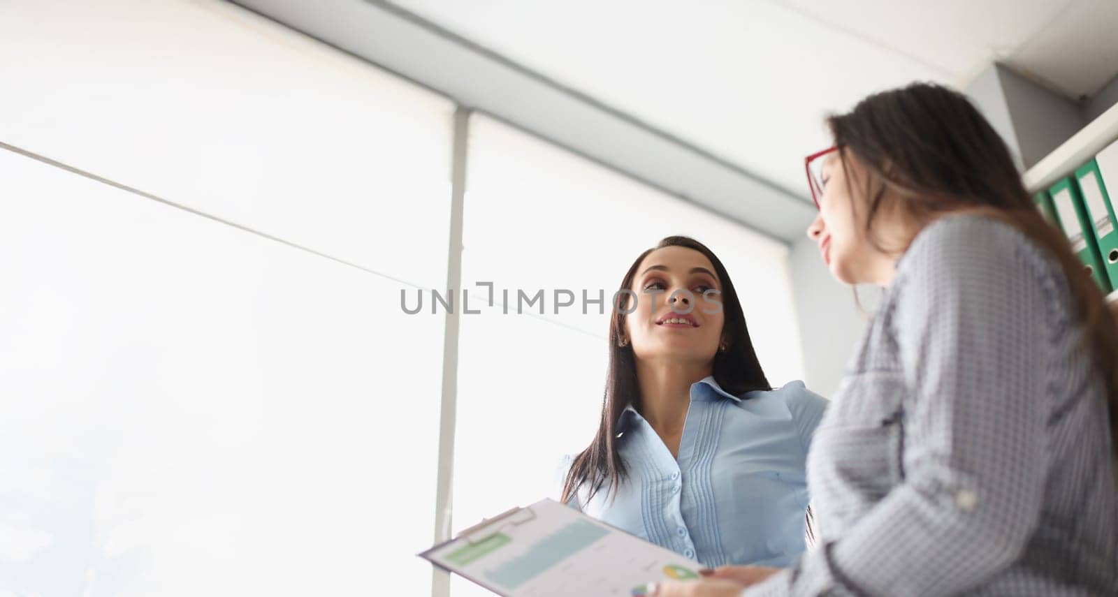 Portrait of female coworkers discussing report business growth and statistics. Colleagues in company office create strategy. Business, job, career concept