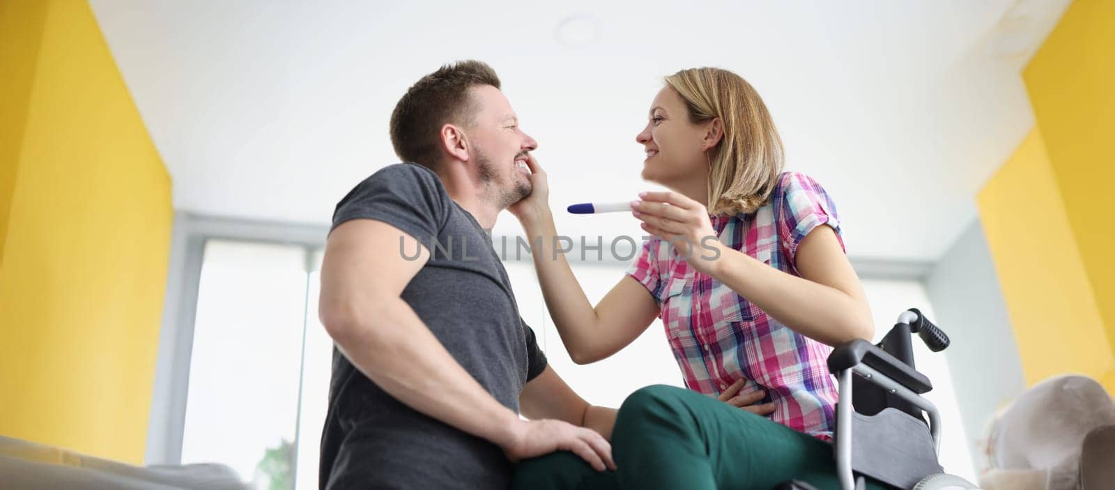 Portrait of happy husband got news about wifes pregnancy, waiting for baby, middle aged man smiles. Woman show positive pregnancy test. Family grow concept