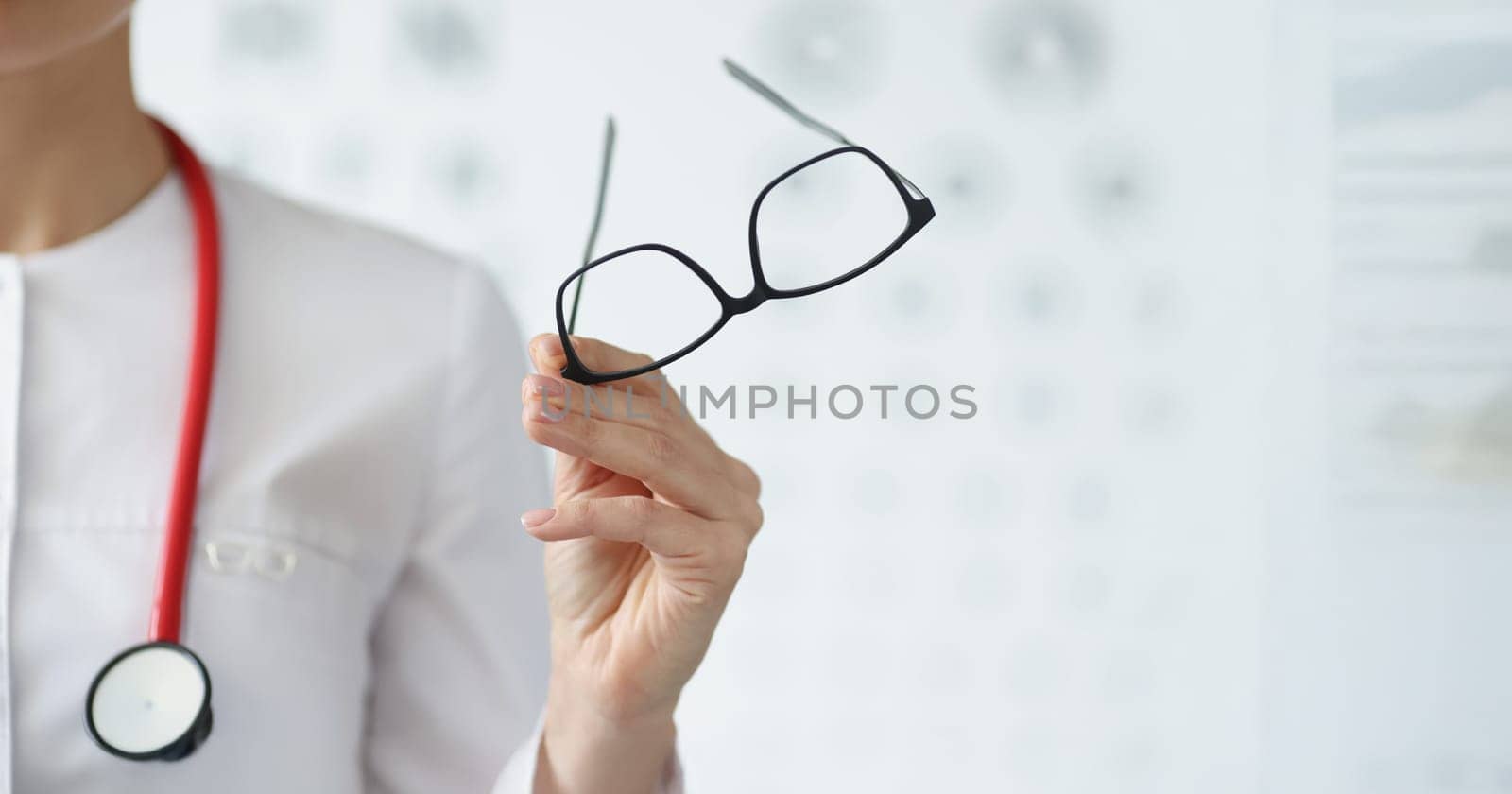 Close-up of professional doctor ophthalmologist hold glasses in black frame. Qualified eye doctor invite on appointment. Vision, medicine, checkup concept