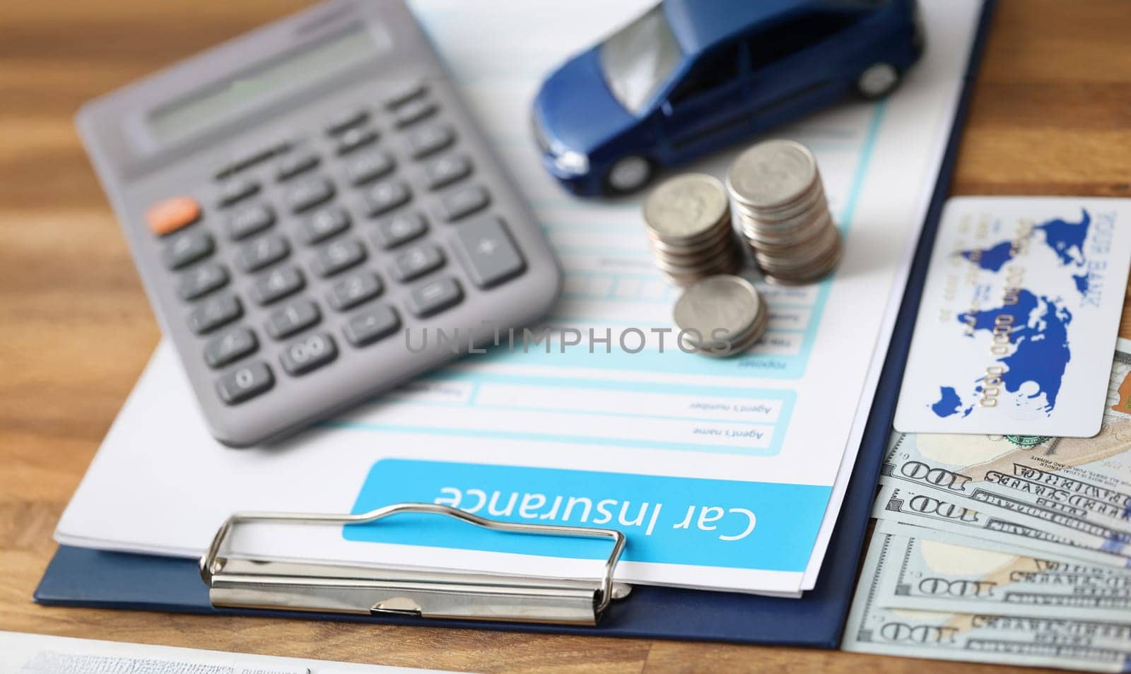 Close-up of car insurance paper calculator stack of coins and banknote on desk. Sign contract and protect your car from accident. Vehicle insurance concept