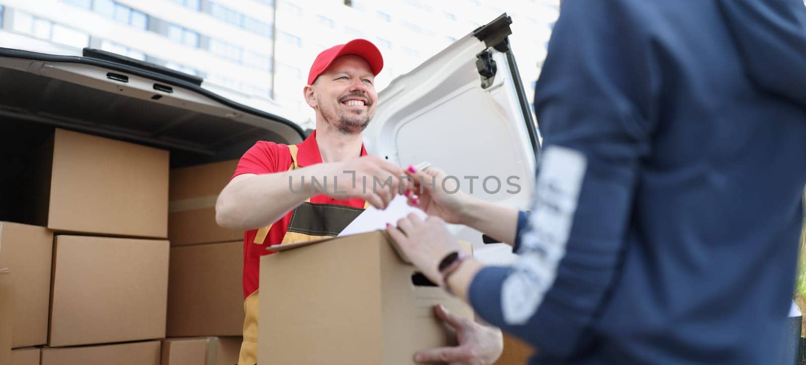 Portrait of courier and receiver make trade with signature on document for order. Worker delivered box fast on personal address. Delivery service concept