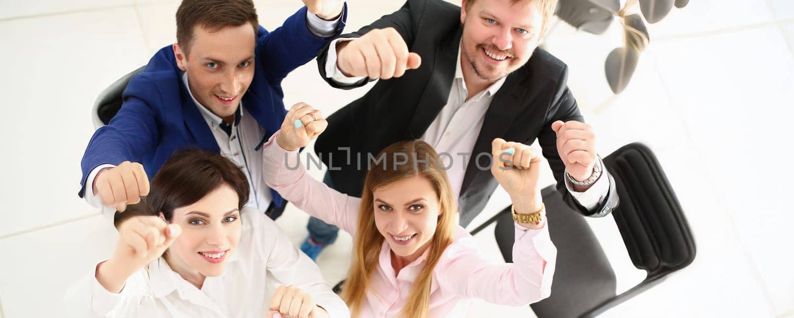 Top view of group of people show support gesture collectively in office. Well dressed workers posing with smile, cheerful mood. Business, teamwork concept