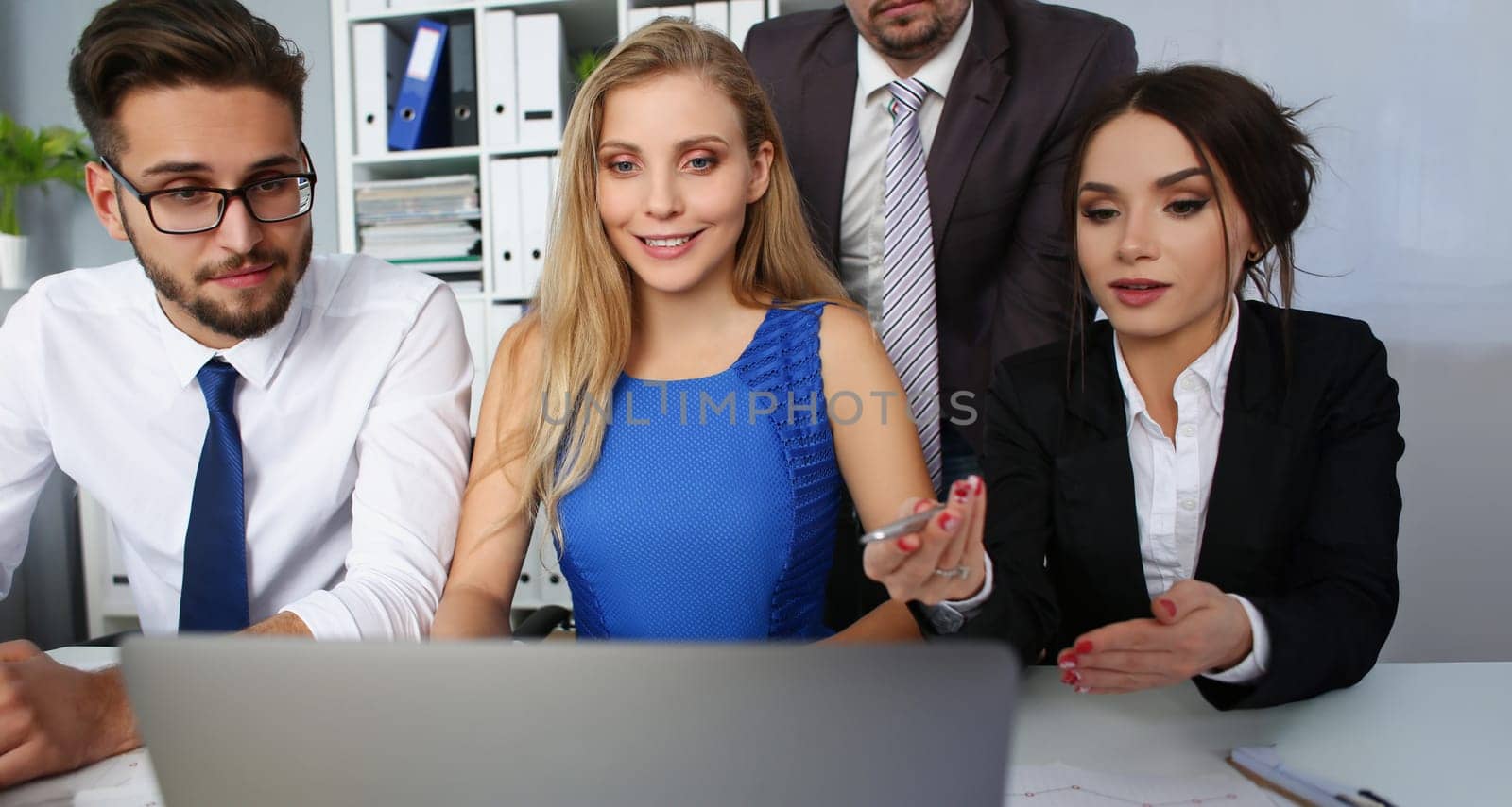 Portrait of group of people in office watch in laptop screen listen to speaker online. Watch internet video at workplace with workers. Fun at work concept