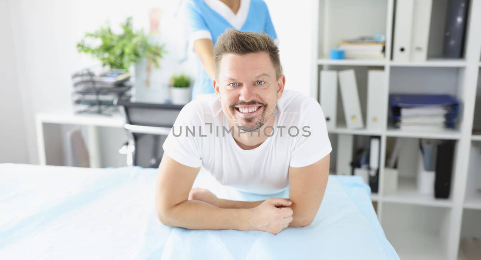 Portrait of woman physiotherapist giving massage to office worker in company cabinet. Short break to relief stress and tension from body. Health concept