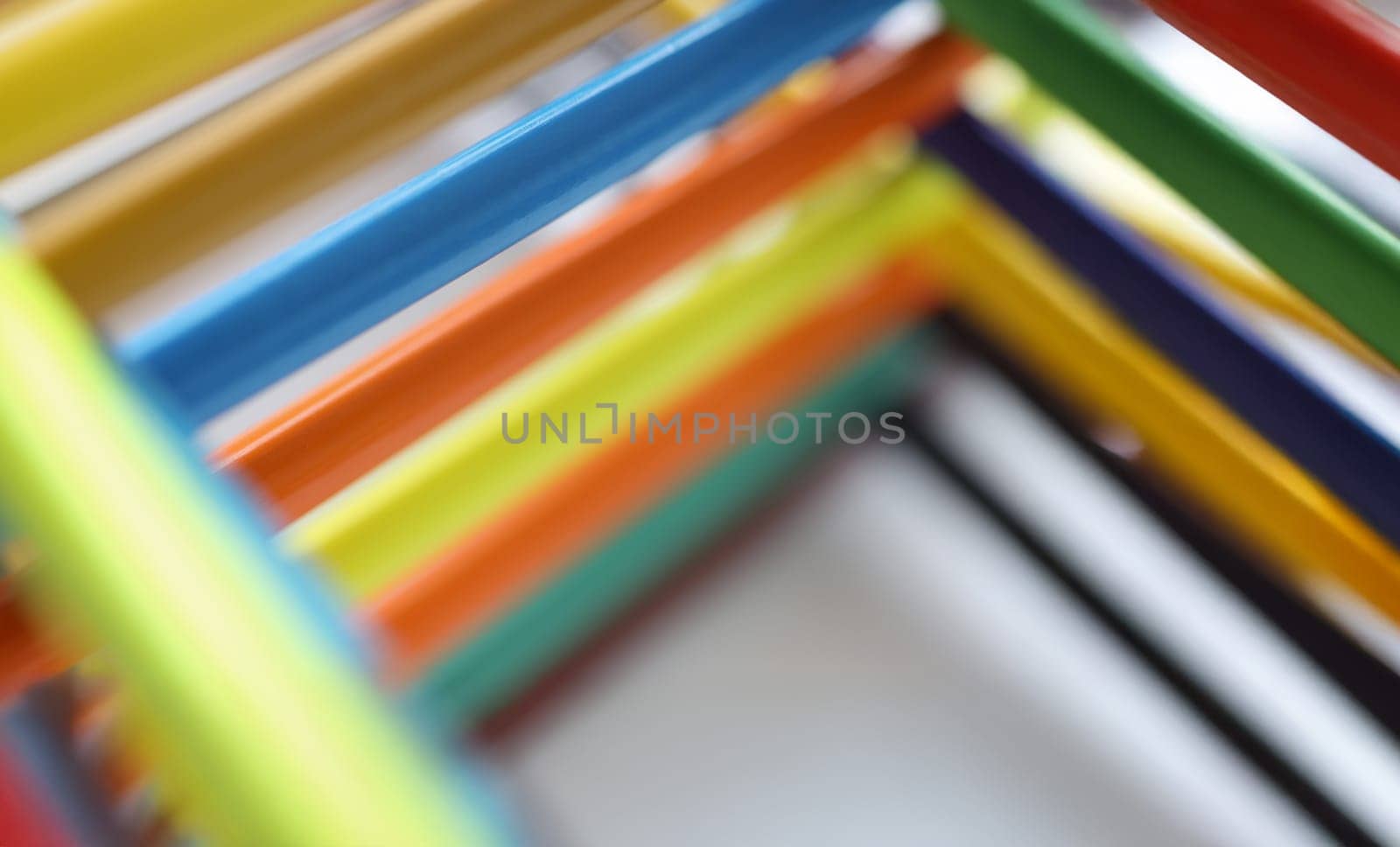 Close-up of pyramid shape made with some different colored wood pencil crayons. Tools for drawing and express your vision. Art, creativity, hobby concept