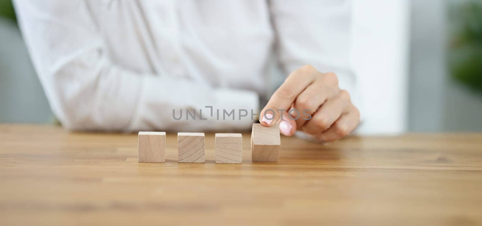 Close-up of business woman flipping one wooden cube from row. Change situation, positive thinking. Success, strategy, solution, progress, business concept