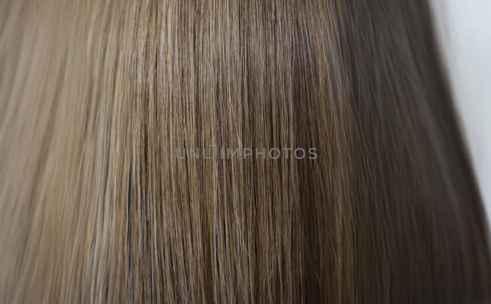 Close-up of straight chestnut natural hair texture after dye procedure in salon. Woman with shiny and luxury quality of hair. Wellness, self care concept