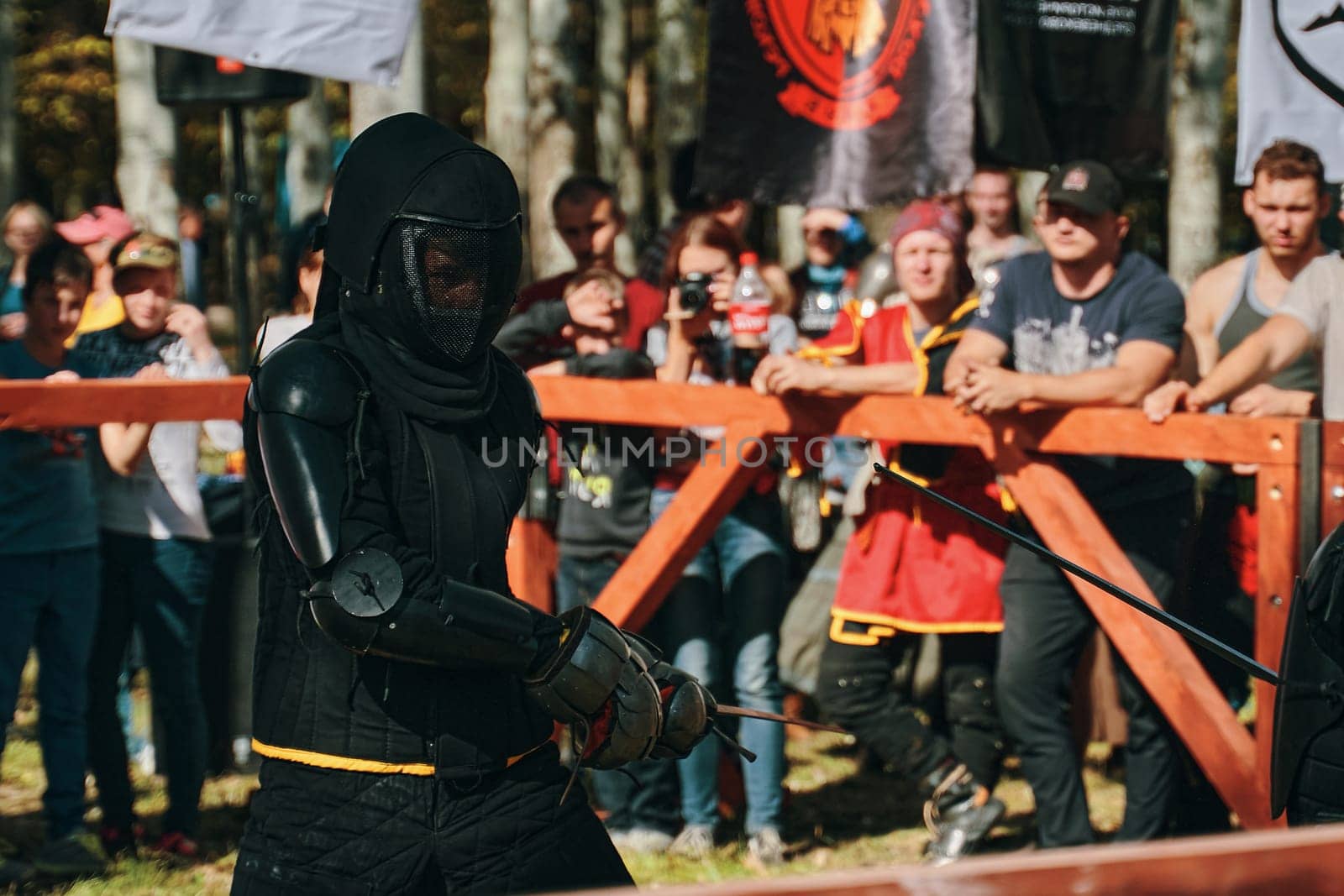 Medieval knight in black clothes with a sword. Reconstruction of medieval battles. Festival of medieval culture. Bishkek, Kyrgyzstan - October 13, 2019