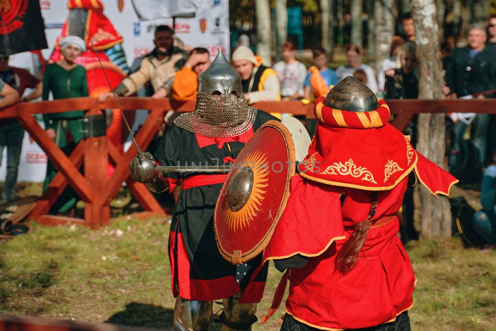 Fights among women in armor. Two females viking posing in front of a group of warriors. Festival of medieval culture. Bishkek, Kyrgyzstan - October 13, 2019