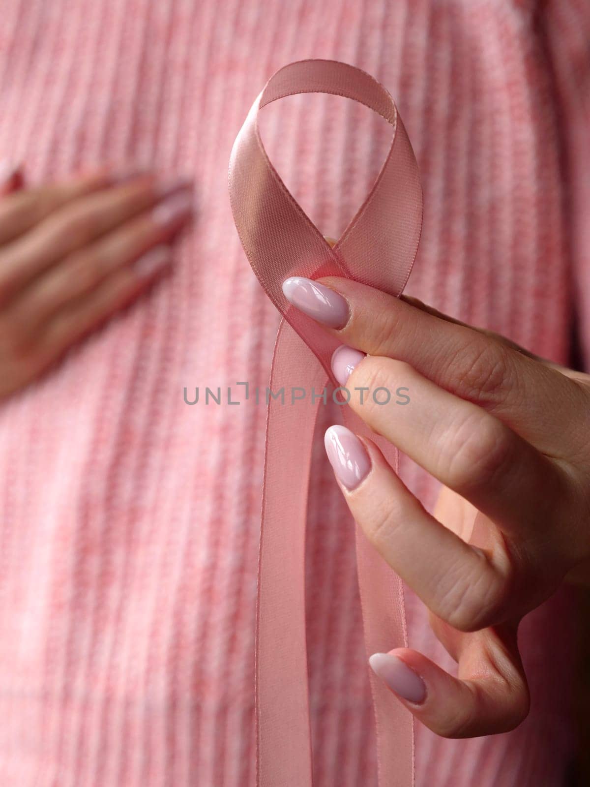 Pink October Breast Cancer Awareness month, woman hand with pink Ribbon in hospital for support people life and illness. Vertical