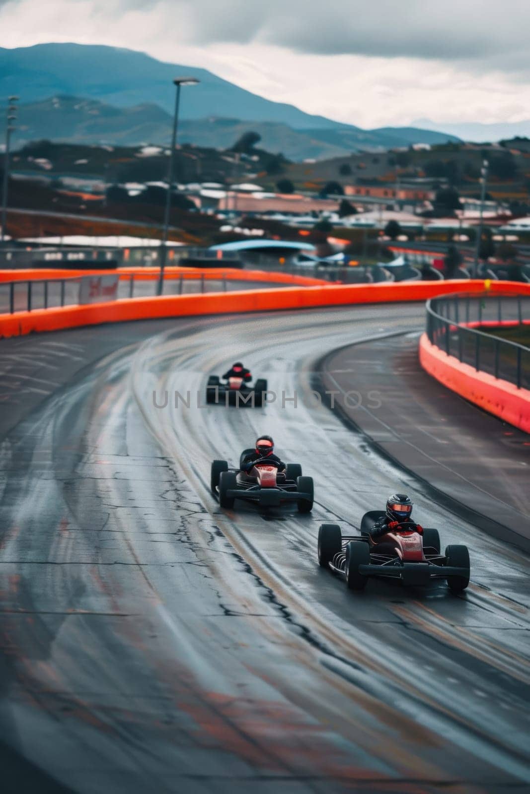 Helmeted racers race karts on an open track, experiencing pleasure and excitement.