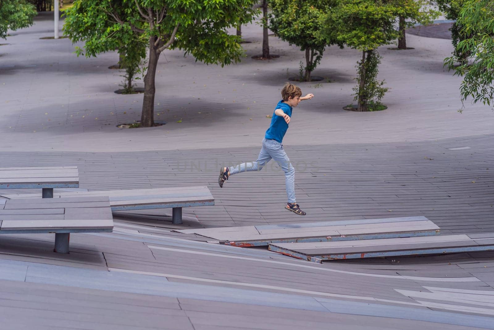 Teenage boy doing parkour in a park. Adventure, movement, and urban sport concept.