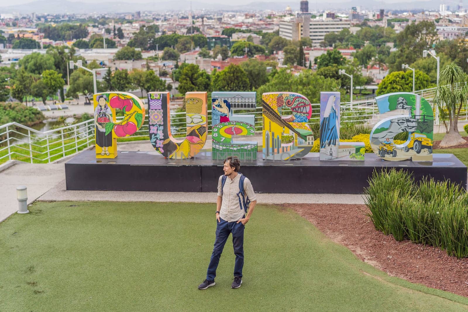 Male tourist in front of the panoramic view of Puebla city, Mexico. Travel, cultural exploration, and scenic landscape concept.