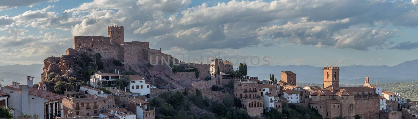 Scenic panoramic view of Vilafames with its illuminated castle and old town at dusk, highlighting its medieval architecture and enchanting atmosphere.