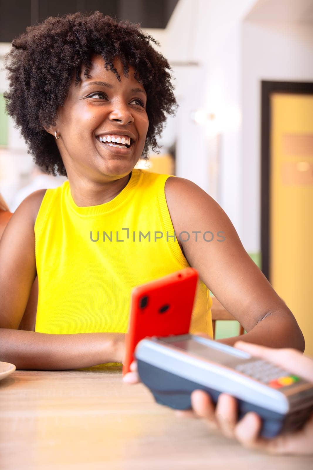Vertical portrait Happy african american woman holding a credit card and making a payment transaction.