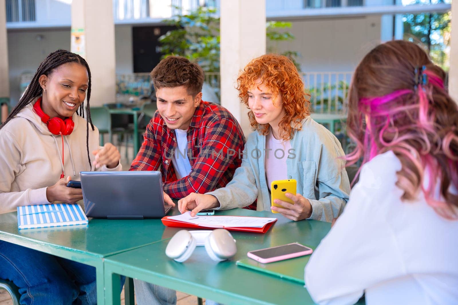 Group of multiethnic students, meet on the university campus, work together on creative tasks, prepare for university exams, use laptops. Education, study of the concept of university life.