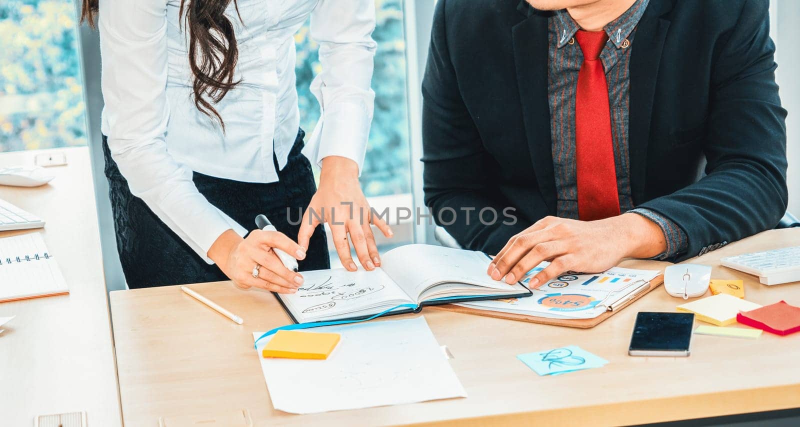 Two business people talk project strategy at office meeting room. Businessman discuss project planning with colleague at modern workplace while having conversation and advice on financial report. Jivy